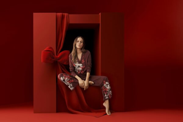 ;odel sitzt in einem SCHIESSER Schlafanzug in einer roten Box