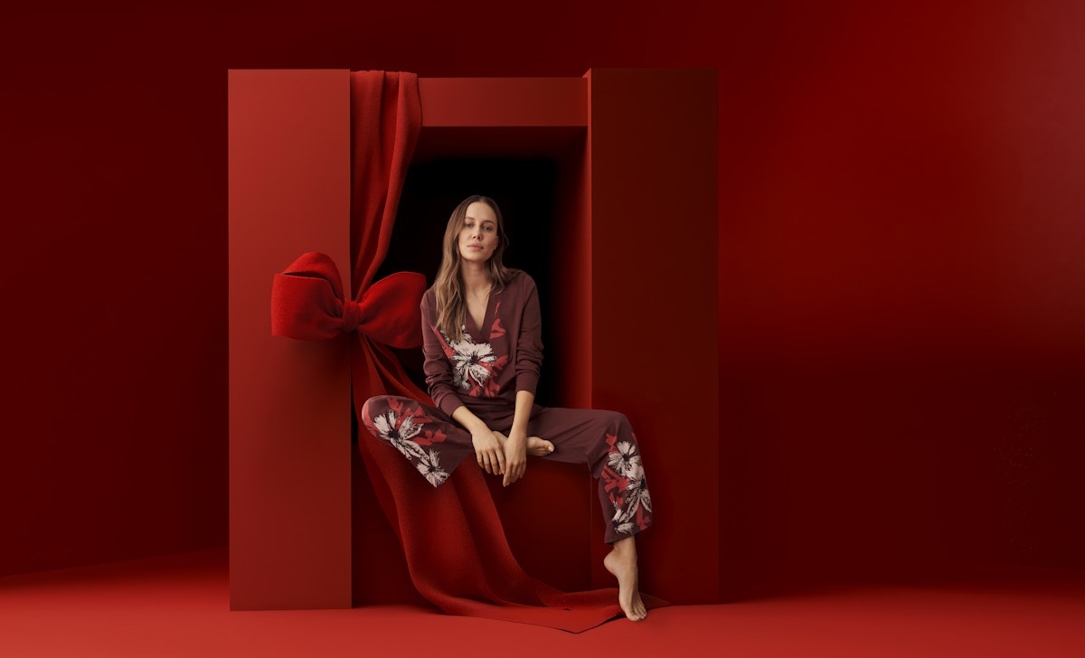 ;odel sitzt in einem SCHIESSER Schlafanzug in einer roten Box