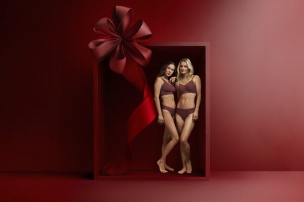 Zwei Models in roter Unterwäsche, bestehend aus rotem BH und rotem Slip - stehen in einer roten Geschenkbox
