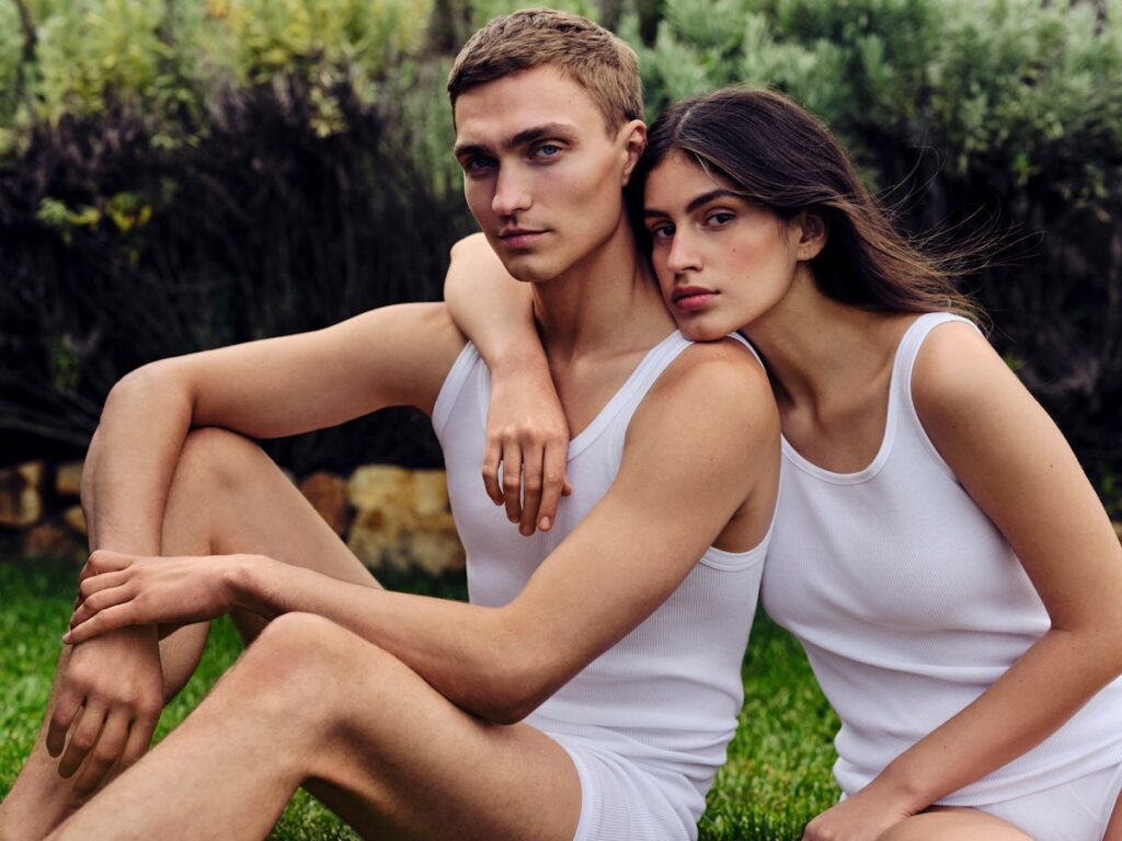 Ein Pärchen sitzt in weißer SCHIESSER-Unterwäsche mit Elasthan auf dem Rasen