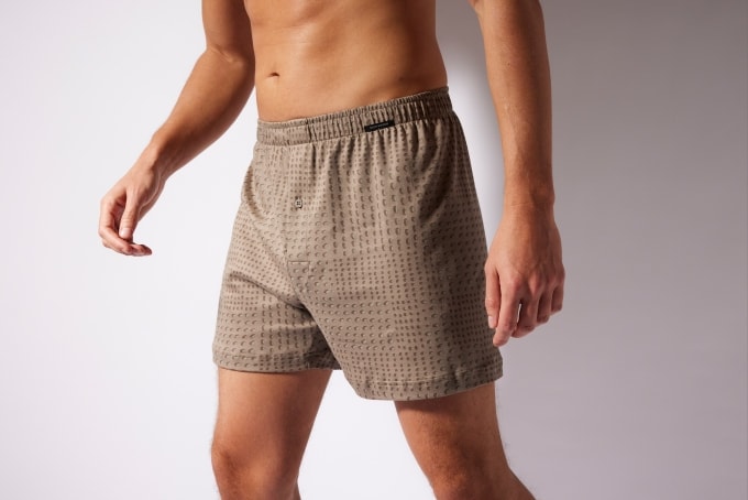 Mann trägt eine locker geschnittene, gemusterte Boxershorts mit elastischem Bund – klassische Passform für maximale Bewegungsfreiheit und hohen Komfort im Alltag.