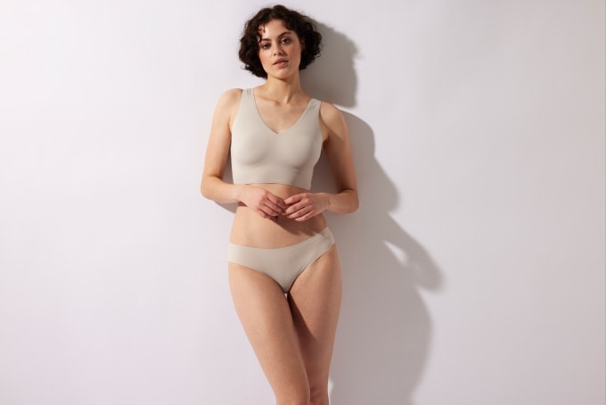 Frau in nahtloser, hautfarbener Unterwäsche mit softem BH und Slip – moderner, glatter Schnitt ohne Nähte für unsichtbaren Look unter der Kleidung und höchsten Tragekomfort.