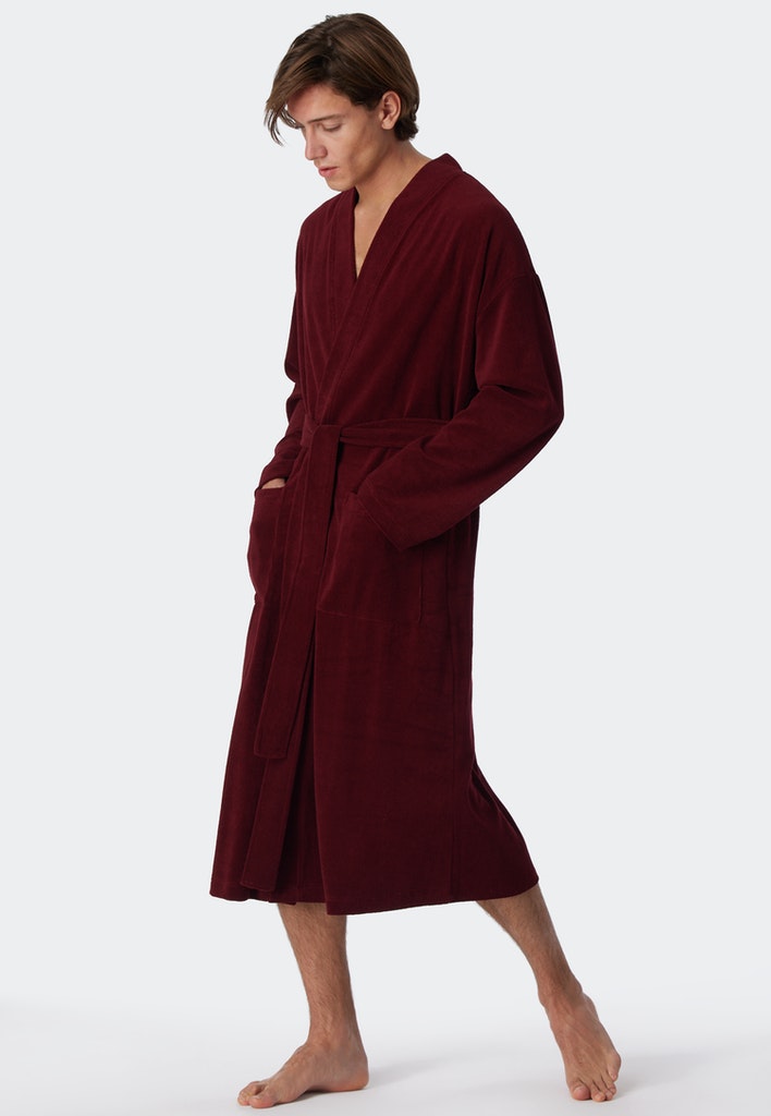 Männliches Model in einem roten Bademantel