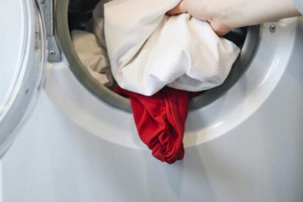 Weiße Wäsche in der Waschmaschine mit einem roten Kleidungsstück